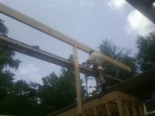 Carpenter setting a ridge beam over a new addition frame — Ice Dam Removal by Roofing Brothers in Corinne